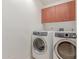 Modern laundry room with front loading washer and dryer and overhead cabinet storage at 16 W Encanto Blvd # 26, Phoenix, AZ 85004
