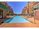 Community pool featuring in-water logo, lounge chairs, and view between buildings at 16 W Encanto Blvd # 26, Phoenix, AZ 85004