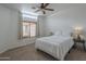 Cozy bedroom features a ceiling fan, large window, and neutral carpet at 1650 S Crismon Rd # 63, Mesa, AZ 85209