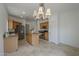 Open kitchen has wood cabinetry, stainless steel appliances, tile floors, and island with chandelier at 1650 S Crismon Rd # 63, Mesa, AZ 85209