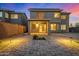 Twilight view of the backyard with paved patio, outdoor lighting, and desert landscaping at 1655 W Stanford Ave, Gilbert, AZ 85233