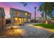 Backyard view featuring a covered patio, paved area, grass, and manicured landscaping at 1655 W Stanford Ave, Gilbert, AZ 85233