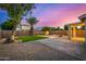 Spacious backyard featuring pavers, turf, desert landscaping, and exterior patio area with lighting at 1655 W Stanford Ave, Gilbert, AZ 85233