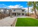 The backyard has pavers, green grass, desert landscaping, a covered patio, and beautiful trees at 1655 W Stanford Ave, Gilbert, AZ 85233