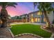 Beautiful backyard featuring grass area, rock borders, desert landscaping and patio at 1655 W Stanford Ave, Gilbert, AZ 85233