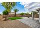 Beautifully landscaped backyard with pavers, grass, desert landscaping, and a covered patio at 1655 W Stanford Ave, Gilbert, AZ 85233