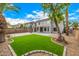 An expansive backyard features pavers, grass, desert landscaping, and a covered patio at 1655 W Stanford Ave, Gilbert, AZ 85233