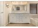 Primary bathroom with dual sinks, granite countertop, and modern lighting fixtures at 1655 W Stanford Ave, Gilbert, AZ 85233