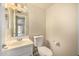 Bright half bath features a vanity with marble countertop and a white toilet at 1655 W Stanford Ave, Gilbert, AZ 85233