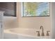 Bright bathroom features a soaking tub with modern fixtures and a window at 1655 W Stanford Ave, Gilbert, AZ 85233
