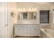 Primary bathroom with dual sinks, granite countertop, and modern lighting fixtures at 1655 W Stanford Ave, Gilbert, AZ 85233
