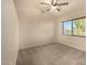A neutrally painted bedroom with carpet, ceiling fan, and a window with blinds at 1655 W Stanford Ave, Gilbert, AZ 85233