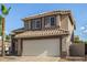 Close up of two-story home with a two-car garage and desert landscaping at 1655 W Stanford Ave, Gilbert, AZ 85233