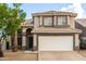 Inviting two-story home with a spacious garage, desert landscaping, and warm exterior lighting at 1655 W Stanford Ave, Gilbert, AZ 85233