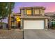 Inviting two-story home with a spacious garage, desert landscaping, and warm exterior lighting at 1655 W Stanford Ave, Gilbert, AZ 85233