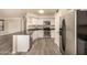 Modern kitchen featuring stainless steel appliances, white cabinets, granite countertops, and wood-style flooring at 1655 W Stanford Ave, Gilbert, AZ 85233