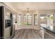 Kitchen with stainless steel appliances, wood-style flooring, and natural light from the adjacent dining area at 1655 W Stanford Ave, Gilbert, AZ 85233