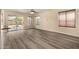 Open-concept living space with wood-look floors, access to backyard, and ceiling fan at 1655 W Stanford Ave, Gilbert, AZ 85233