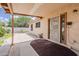 A covered patio with a door leading to a backyard featuring desert plants and a concrete walkway at 1660 E Zinnia St, Casa Grande, AZ 85122