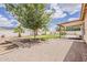 A backyard featuring grass, gravel, desert landscaping, and a covered patio at 1660 E Zinnia St, Casa Grande, AZ 85122