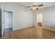 Bright bedroom featuring wood-look floors, ceiling fan and ensuite bathroom access at 1660 E Zinnia St, Casa Grande, AZ 85122