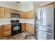 Well-lit kitchen featuring stainless steel refrigerator, range oven, and wooden cabinetry at 1660 E Zinnia St, Casa Grande, AZ 85122