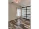 Cozy bedroom featuring a decorative light fixture, a large mirrored closet, and stylish wood-look tile flooring at 17225 W Carmen Dr, Surprise, AZ 85388