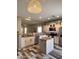 Modern kitchen with granite counters, stainless steel appliances, center island, pendant lighting and wood-look tile floors at 17225 W Carmen Dr, Surprise, AZ 85388