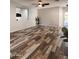 Open living room featuring wood-look tile floors, modern lighting, and neutral walls, creating a spacious and inviting area at 17225 W Carmen Dr, Surprise, AZ 85388