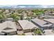 Overhead view of a home in a desert neighborhood, showcasing a pool and a beautiful mountain range in the background at 19002 N Arbor Dr, Maricopa, AZ 85138