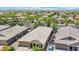 Aerial view featuring homes in a residential area, showcasing manicured desert landscaping and palm trees at 19002 N Arbor Dr, Maricopa, AZ 85138
