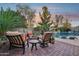 Outdoor space featuring a fire pit and comfortable chairs next to a beautiful pool with a waterfall feature at 19002 N Arbor Dr, Maricopa, AZ 85138
