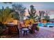 Outdoor space featuring a fire pit and comfortable chairs next to a beautiful pool with a waterfall feature at 19002 N Arbor Dr, Maricopa, AZ 85138