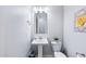 Powder room featuring a pedestal sink, a decorative mirror, and soft lighting, creating a welcoming space at 19002 N Arbor Dr, Maricopa, AZ 85138