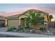 Single story home featuring a well manicured yard with desert landscaping, a large garage, and a covered porch at 19002 N Arbor Dr, Maricopa, AZ 85138