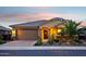 Charming single-story home boasting lush desert landscaping, inviting entry, and warm lighting at 19002 N Arbor Dr, Maricopa, AZ 85138