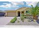 Home featuring a well manicured yard with desert landscaping, a large garage, and a covered porch at 19002 N Arbor Dr, Maricopa, AZ 85138