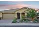 Home featuring a well manicured yard with desert landscaping, a large garage, and a covered porch at 19002 N Arbor Dr, Maricopa, AZ 85138
