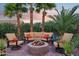 Cozy outdoor firepit surrounded by comfortable seating and lush tropical landscaping beneath a colorful sunset sky at 19002 N Arbor Dr, Maricopa, AZ 85138