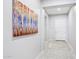 Inviting hallway features neutral tile, modern art, and access to the home's entrance, exuding a sense of calm at 19002 N Arbor Dr, Maricopa, AZ 85138