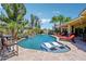 Amazing backyard with a refreshing pool, water features, lounge chairs, and lush greenery, creating a private retreat at 19002 N Arbor Dr, Maricopa, AZ 85138