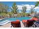 Resort-style pool with water feature and lounge chairs, surrounded by lush desert landscaping under a sunny sky at 19002 N Arbor Dr, Maricopa, AZ 85138