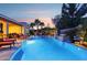 Inviting backyard oasis with a sparkling pool, palm trees, lounge chairs, and a cozy outdoor seating area at sunset at 19002 N Arbor Dr, Maricopa, AZ 85138