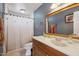 Bathroom featuring a wood vanity, white sink and shower with decorated curtain at 19615 N 18Th Dr, Phoenix, AZ 85027