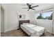 Bright bedroom features wood floors, ceiling fan, and a large window at 19615 N 18Th Dr, Phoenix, AZ 85027