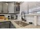 Bright kitchen with stainless steel sink, granite countertops, subway tile backsplash, and gray cabinetry at 19615 N 18Th Dr, Phoenix, AZ 85027