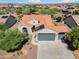 Aerial view of a house with tile roof, solar panels, desert landscaping, and spacious three car garage at 21532 N 262Nd Ln, Buckeye, AZ 85396