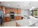 Well-equipped kitchen with stainless steel appliances, granite countertops, and adjacent breakfast bar at 21532 N 262Nd Ln, Buckeye, AZ 85396