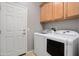 Well-equipped laundry room featuring a washer, dryer, and overhead cabinets for storage at 21532 N 262Nd Ln, Buckeye, AZ 85396