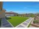 Lush backyard features manicured synthetic lawn, a decorative pergola, and vibrant landscaping at 2518 E Novak Way, Phoenix, AZ 85042